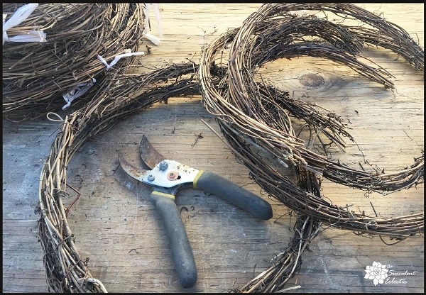cutting twig garland to make a grapevine heart wreath