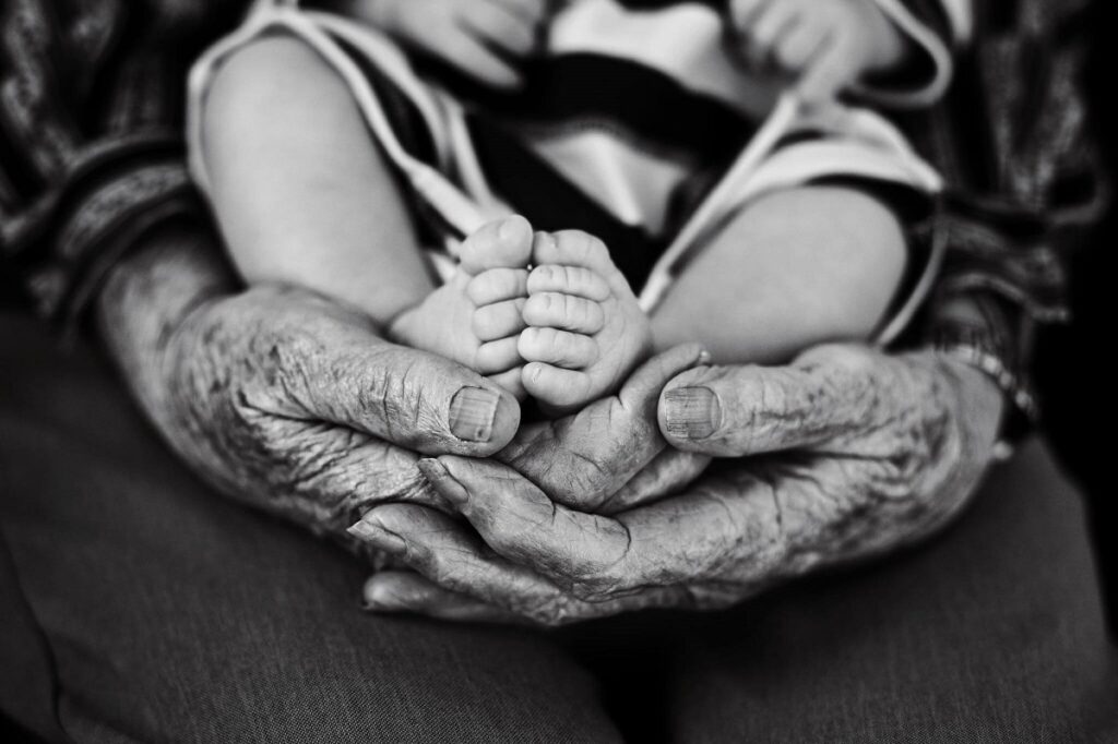 Photograph of a great grandmother holding child illustrates the design principle contrast